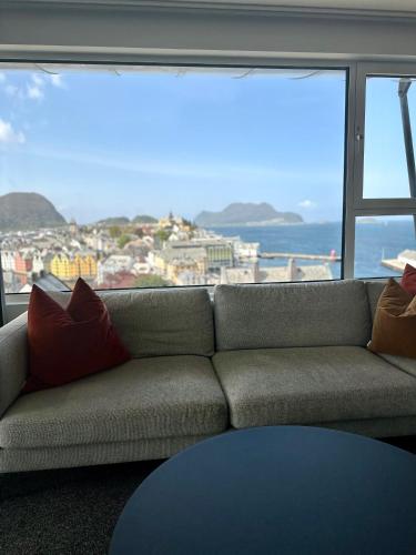 a couch in a room with a view of the ocean at Scandic Parken in Ålesund