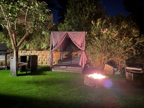 a hammock in a tent in a yard at night at Love Room L'ecrin d'Asteria in Laudun