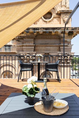 a table with a plate of food on a balcony at Florette Suite 1BR with Stunning Lounge Terrace by ArcoBnb in Il-Furjana