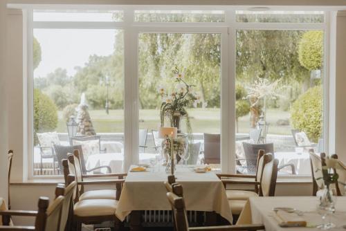 a dining room with tables and chairs and a large window at Landhotel Stähle in Schüttorf
