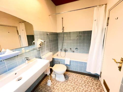 a bathroom with a tub and a toilet and a sink at Gästehaus Sophienstraße in Stuttgart
