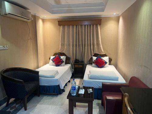 a hotel room with two beds and a couch at Sea Shell Suites in Kāmarpāra