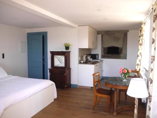 a bedroom with a bed and a table and a kitchen at Château Marnand - Studio Montgolfière in Granges-près-Marnand