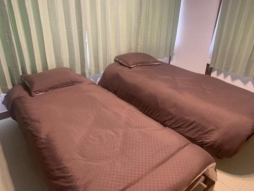 two beds sitting next to each other in a bedroom at LT IZU Usami UMI in Ito