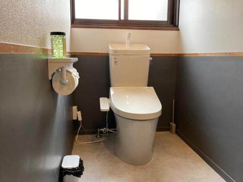 a small bathroom with a toilet and a window at LT IZU Usami UMI in Ito