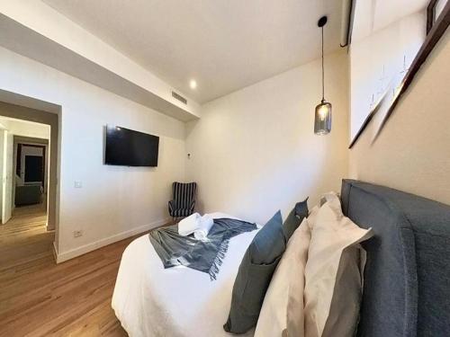 a bedroom with a bed and a tv on the wall at Blue Apartment in Puerto del Rosario in Puerto del Rosario
