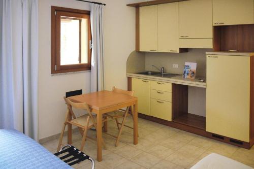 a small kitchen with a small table and a table and chairs at Apartment in Porto Pollo near Sea Beach in Porto Pollo