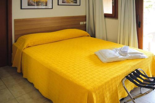 a yellow bed with two towels on top of it at Apartment in Porto Pollo near Sea Beach in Porto Pollo