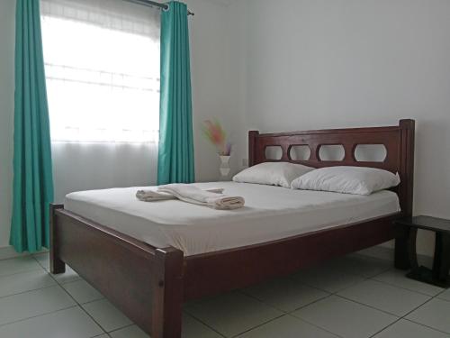 a bedroom with a large bed with green curtains at Ranks Comfy Homes in Mombasa