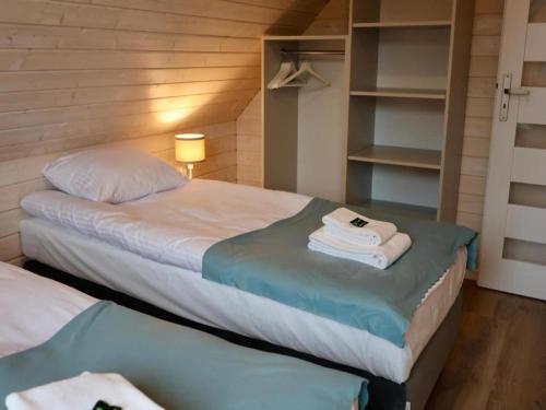 a bedroom with two beds with towels on them at Comfortable house by the beach in Stepnica in Stepnica