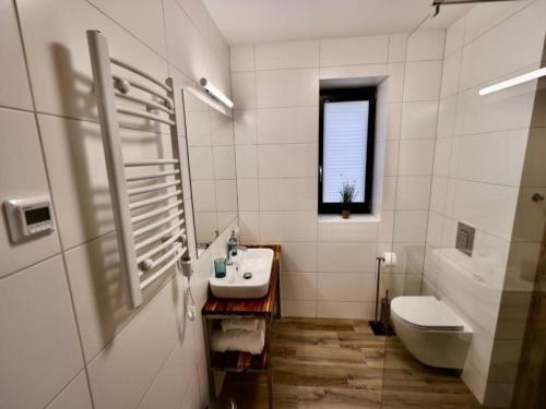 a white bathroom with a sink and a toilet at Comfortable house by the beach in Stepnica in Stepnica