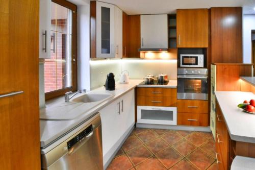 a kitchen with white counters and wooden cabinets at Comfortable holiday villa, Święcianowo in Zegocino