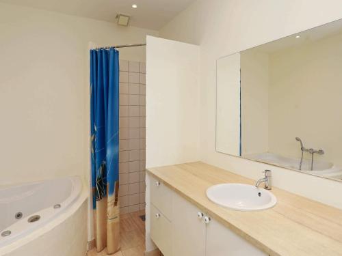 a bathroom with a sink and a tub and a mirror at 6 person holiday home in Skagen-By Traum in Skagen