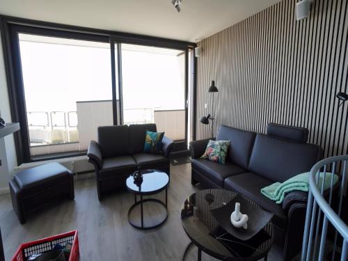 a living room with a couch and a table at Penthouse Wohnung direkt am Nodseestrand in Wyk auf Föhr