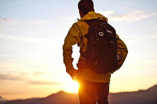 a man with a backpack looking at the sunset at Apartment building, Fügen in Fügen