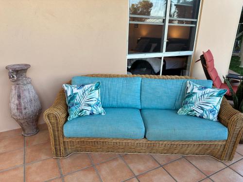 a blue couch sitting in a room with a window at River Rock Retreat in Maroochy River