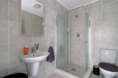 Un baño con ducha, lavabo e inodoro. en #AlimamaSpaces Pano's Greenpark, en Boksburg
