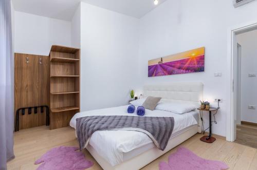a bedroom with a large white bed with purple rugs at Villa Mariva in Žminj