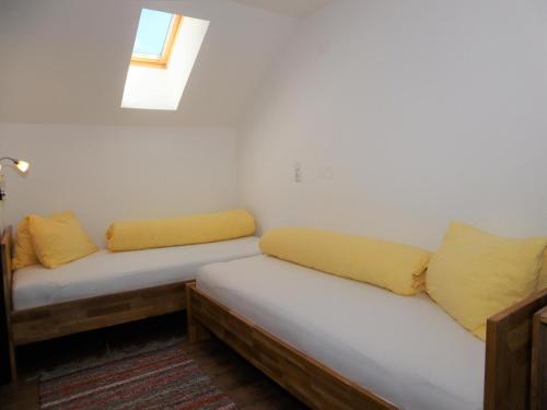 a room with two beds with yellow pillows and a window at Flat in Krimml with a balcony in Krimml