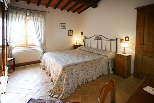 a bedroom with a large bed and a window at Casale Giacomini in Manciano