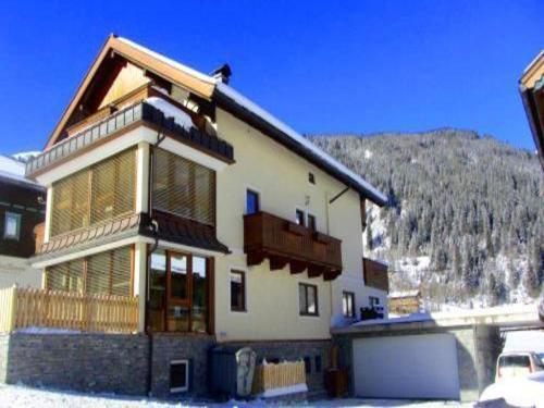 a large house with a mountain in the background at Flat in Krimml with a balcony in Krimml