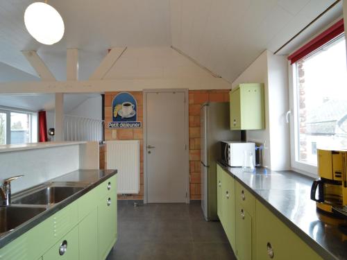 a kitchen with green cabinets and a sink at Stylish Duplex with Sauna in Modave