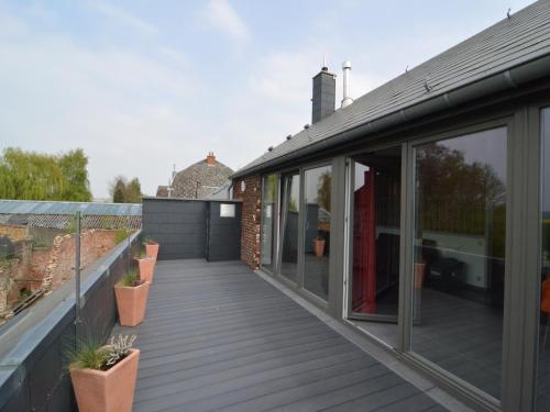 an extension to a house with a deck at Stylish Duplex with Sauna in Modave
