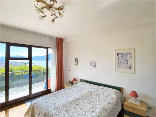 a bedroom with a bed and a large window at Belvilla by OYO VC02 7 - Villa Castiglioni in Luino