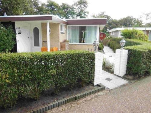 a small house with a hedge in front of it at Pretty home in Sint Maartenszee in Sint Maartenszee