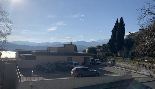 a parking lot with cars parked in front of a building at FLAT WITH AMAZING VIEW OVER THE GULF OF LUGANO in Lugano