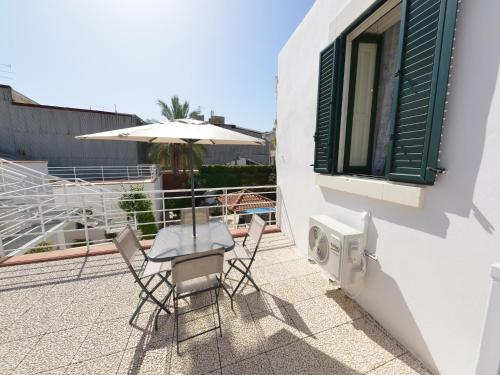 a patio with a table and chairs and an umbrella at Vacation home with private pool, Floridia in Floridia