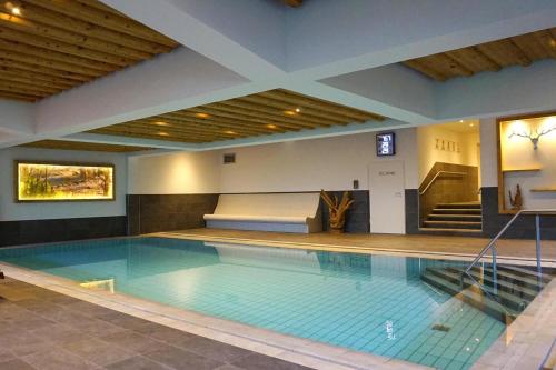 a large swimming pool with a bed in a building at Apartments Schatzberg-Haus, Wildschönau-Auffach in Auffach