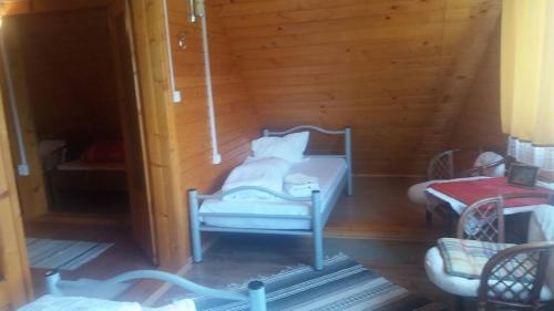 a toy room with a bed and two chairs at Pensiunea Casa Motilor in Bucium