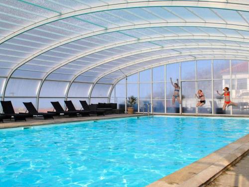 a swimming pool with people jumping in the water at Storløkke Holiday Park in Allinge