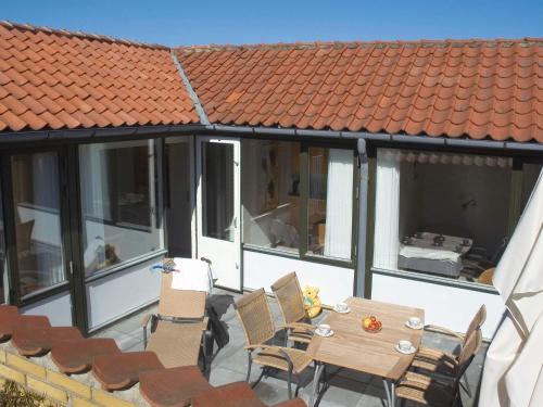 a patio with a table and chairs and a roof at Storløkke Holiday Park in Allinge
