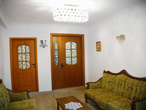 a living room with a couch and two doors at Villa Marie 23 in Gjirokastër