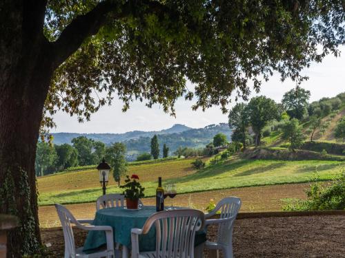 a table and chairs under a tree with a view at Cosy apartment with bubble bath in Perugia