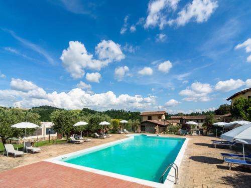 a pool at a resort with chairs and umbrellas at Cosy apartment with bubble bath in Perugia