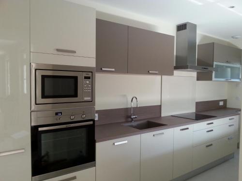 a kitchen with a microwave oven and a sink at Gite du Domaine du Haut Perron in Thésée