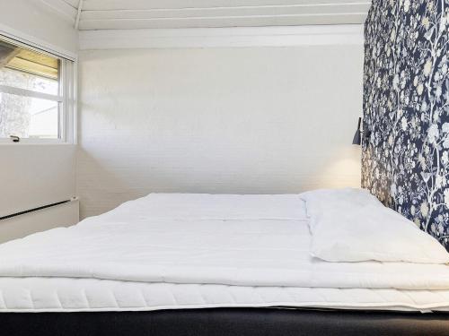 a white bed in a room with a window at Karrebæksminde Fjord Houses in Karrebæksminde