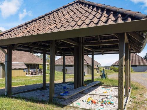 a wooden gazebo with a roof in a yard at Karrebæksminde Fjord Houses in Karrebæksminde