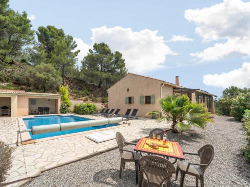 CébazanにあるCharming French Villa with Poolのプールサイドのパティオ(テーブル、椅子付)