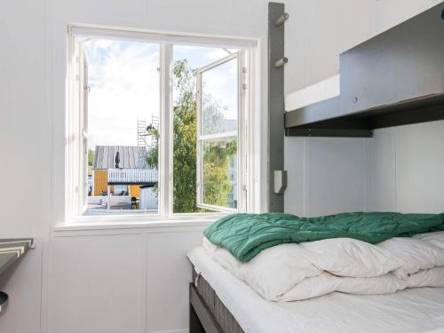 a bedroom with a bed with a large window at Islands Maritime Holiday Village Ebeltoft in Ebeltoft