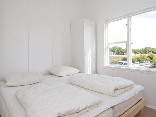a white bedroom with two white pillows on a bed at Islands Maritime Holiday Village Ebeltoft in Ebeltoft