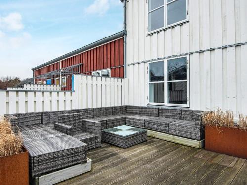 a patio with wicker furniture on a building at Islands Maritime Holiday Village Ebeltoft in Ebeltoft