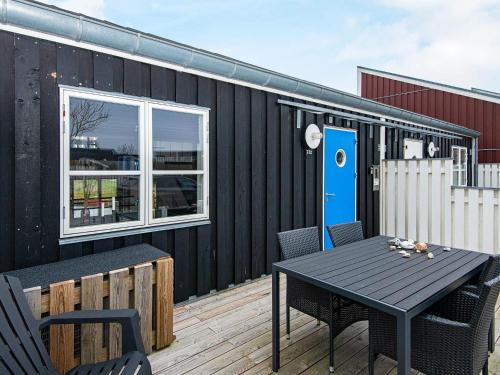 a black building with a table and chairs on a deck at Islands Maritime Holiday Village Ebeltoft in Ebeltoft