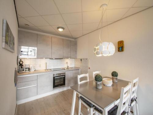 Una cocina con una mesa y sillas en una habitación. en Gorgeous seaside apartment, en Julianadorp