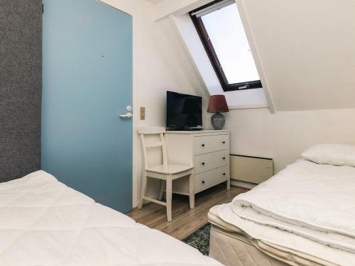 a bedroom with two beds and a tv and a window at Møn - Klintholm Havn Holiday Center in Borre