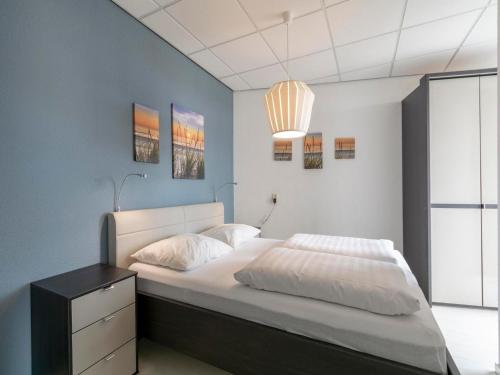 a bedroom with a large bed with a black dresser at Beachside home with balcony in Julianadorp