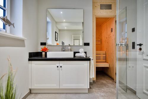 een badkamer met een wastafel en een spiegel bij Haus Dock 10 in Westerland